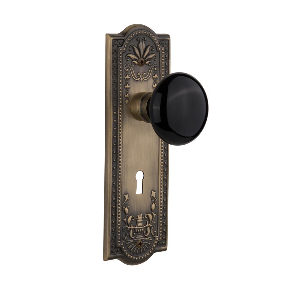 Nostalgic Warehouse MEABLK Passage Knob Meadows Plate with Black Porcelain Knob with Keyhole in Antique Brass